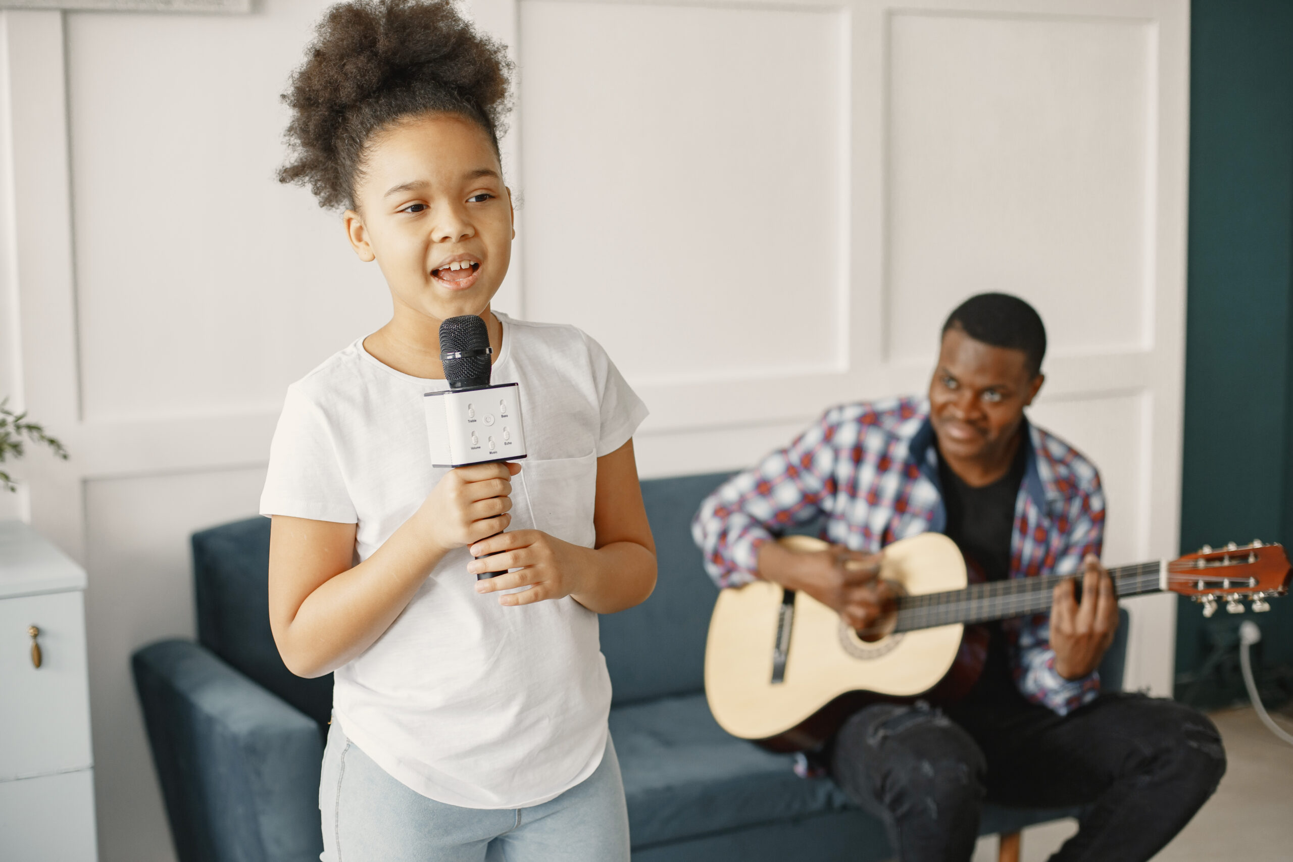 Dad on couch. Girl with a microphone. Man with a guitar.